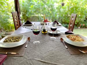 
a table topped with plates of food and glasses of wine at Dream Garden in Arugam Bay
