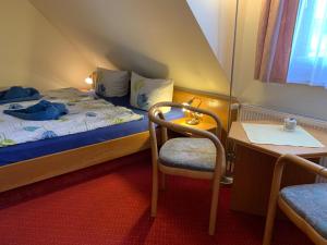 a small room with a bed and a table and a chair at Pension Richter in Ueckeritz