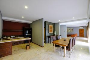 
a kitchen with a table, chairs and a refrigerator at The Westlake Hotel & Resort Yogyakarta in Yogyakarta
