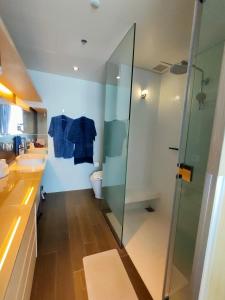 een badkamer met een glazen douche en een toilet bij Veranda Residence by VS in Na Jomtien
