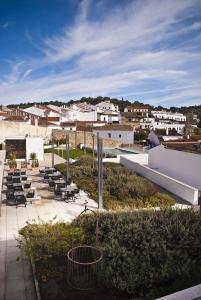 een patio met een aantal stoelen en gebouwen bij Hotel Convento Aracena & SPA in Aracena