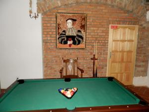 uma mesa de bilhar verde num quarto com uma pintura em Dwór Strzyżew em Żelazowa Wola