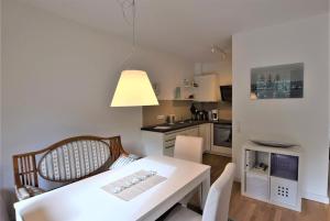a small kitchen with a white table and chairs at Ferienwohnung-Moin in Hohwacht