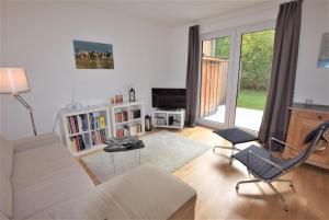 Una sala de estar con un sofá y un televisor. en Ferienwohnung-Moin, en Hohwacht