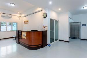 an office with a reception desk and a clock on the wall at Kanyanat Boutique Hotel in Lampang