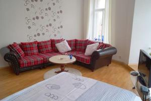 a living room with a red couch and a table at Ferienwohnung Schlossblick Altenburg in Altenburg