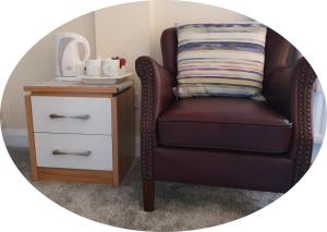 a brown chair next to a side table with a mirror at The Bowers Bar & Restaurant in Ballinrobe