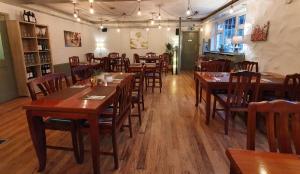 uma sala de jantar com mesas e cadeiras de madeira em The Bowers Bar & Restaurant em Ballinrobe