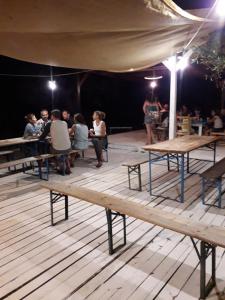 a group of people sitting at tables on a stage at Macarìa Agricampeggio in Alliste