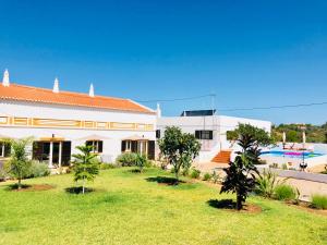un edificio bianco con un cortile alberato e una piscina di Quinta David ad Alvor