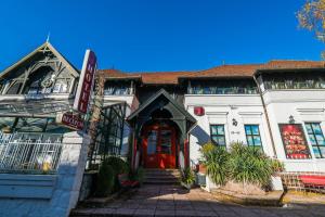 um grande edifício branco com uma porta vermelha em Janus Boutique Hotel & Spa em Siófok