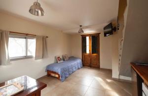 een woonkamer met een bed en een raam bij Cabaña Anita in Merlo