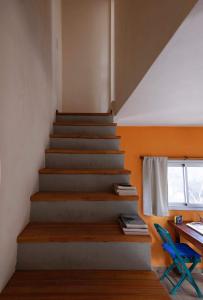 Una escalera en una casa con escritorio y silla azul en Cabaña Anita en Merlo