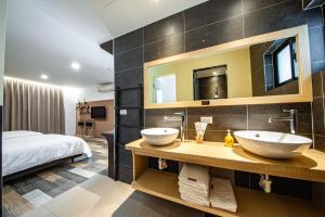 a bathroom with two sinks and a bed at 澎湖 就這兒旅居 in Magong