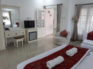 uma sala de estar com uma cama e uma televisão em Surokarsan 9 House Yogyakarta em Yogyakarta