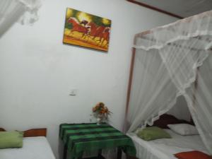 Una habitación con dos camas y una mesa dentro. en Khongaha Villa Holiday Home, en Mirissa