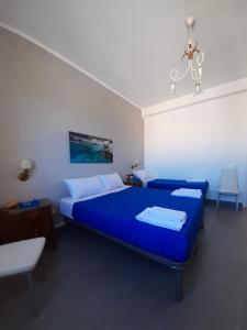 una camera da letto con un letto blu in una stanza di Le Quattro Isole a Marsala