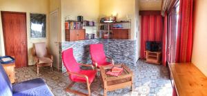 - un salon avec des chaises rouges et une cheminée en pierre dans l'établissement Amarys 2, à Germignaga