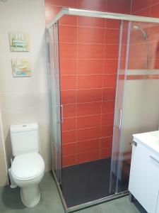een badkamer met een toilet en een glazen douchedeur bij Apartamento Ca'Sara in Soria