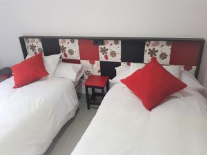 2 camas con almohadas rojas y blancas en una habitación en Apartamento Ca'Sara, en Soria