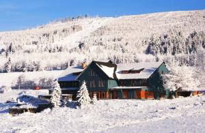 una casa en la nieve en una colina nevada en Renerovka 93, en Dolní Malá Úpa