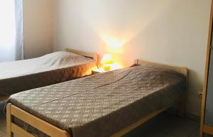 twee bedden in een kleine kamer met een lamp op een tafel bij l'Oustal des Bancs in Saint-Joseph-des-Bancs