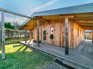 uma casa de madeira com um grande deque de madeira em Quaint Chalet in Harreberg with Garden em Harreberg