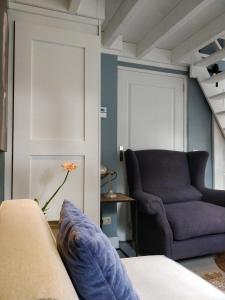 't Hofhuys Oss في أوس: غرفة معيشة مع أريكة وكرسي