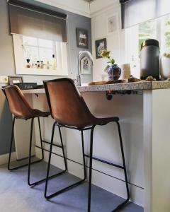 a kitchen with two chairs at a counter at 't Hofhuys Oss in Oss