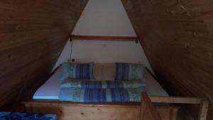 a bed in the attic of a house at Chaty v Českém ráji u Prachovských skal Chata pro 4 a pro až 7 osob - v soukromí in Holín