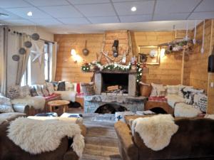a living room with a fireplace with couches and a fire place at Hôtel Restaurant Domaine de l'Adoux in Saint-Jean