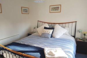 a bedroom with a bed with pillows on it at The Garden Room in Chichester