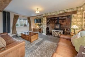 a living room with a couch and a fireplace at Shave Farm in Chard