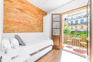 a bedroom with a bed and a large window at Sant Pau Ramblas Apartments Serennia in Barcelona