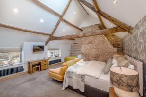 een slaapkamer met een bed en een bakstenen muur bij Shave Farm in Chard