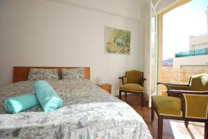 ニースにあるLes Gérardines, 3-room with Airco and balconyのベッドルーム1室(ベッド1台、椅子2脚、窓付)