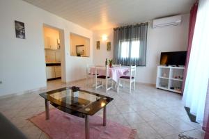 a living room with a table and a dining room at Apartments Marinela in Njivice