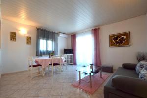 a living room with a table and a couch at Apartments Marinela in Njivice
