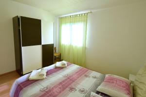 a bedroom with a bed with towels on it at Apartments Marinela in Njivice