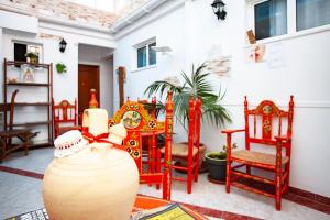 een kamer met rode stoelen en een vaas op een tafel bij Pension Hidalgo 1 in Utrera