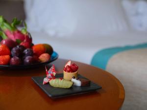 a plate of food on a table with a bowl of fruit at ANA InterContinental Manza Beach Resort by IHG in Onna