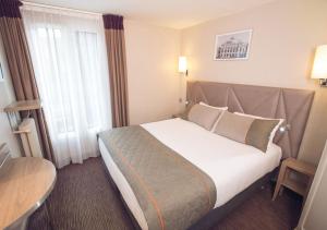 
A bed or beds in a room at Timhotel Paris Gare Montparnasse
