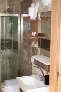 a bathroom with a shower and a sink and a toilet at Lavinia Otel in Cesme