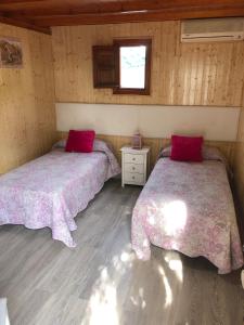 two beds in a room with wooden walls and wooden floors at Camping Torremolinos in Torremolinos