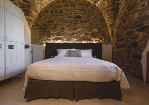 a bedroom with a large bed in a brick wall at Torre di Baratti Bio Resort in Populonia