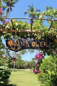 um sinal que lê clube de jardim com flores em Andaman Sunflower em Ko Lanta