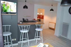 a kitchen with three bar stools and a counter at Jolie T2 au coeur du bourg in Carnac