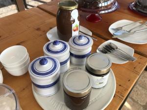 a table with a plate with jars of food on it at Torre di Baratti Bio Resort in Populonia