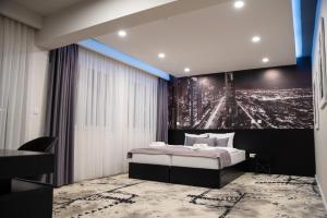 Dormitorio con cama y póster de ciudad en Hotel Biss, en Zenica