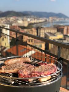 two sausages and meat are cooking on a grill at Casa sul mare in Salerno